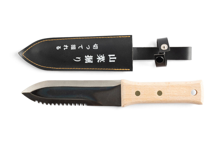 The maru Hori Hori Japanese Gardening Tool-Carbon Steel, featuring a serrated edge and wooden handle, sits elegantly alongside its black leather sheath, perfect for diverse outdoor tasks.