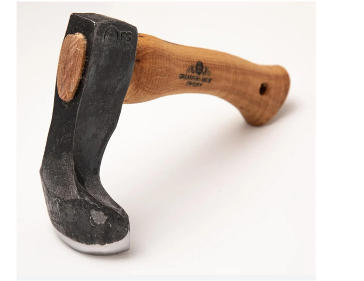 A close-up of the Gränsfors Bruk Small Gutter Adze Radius 40 Second Grade by Gransfors Bruk, featuring a curved wooden handle and a blackened, slightly worn blade—ideal for hollowing timber in log building—set against a plain white background.