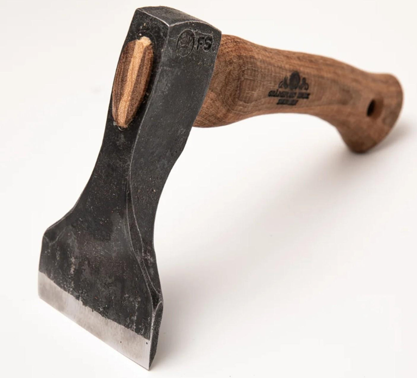 A close-up of the Gransfors Small Straight Adze 80 mm woodworking tool by Gransfors Bruks, featuring a black metal blade and a curved wooden handle, photographed on a plain white background. This tool, commonly used in log building, has a wide, flat cutting edge.