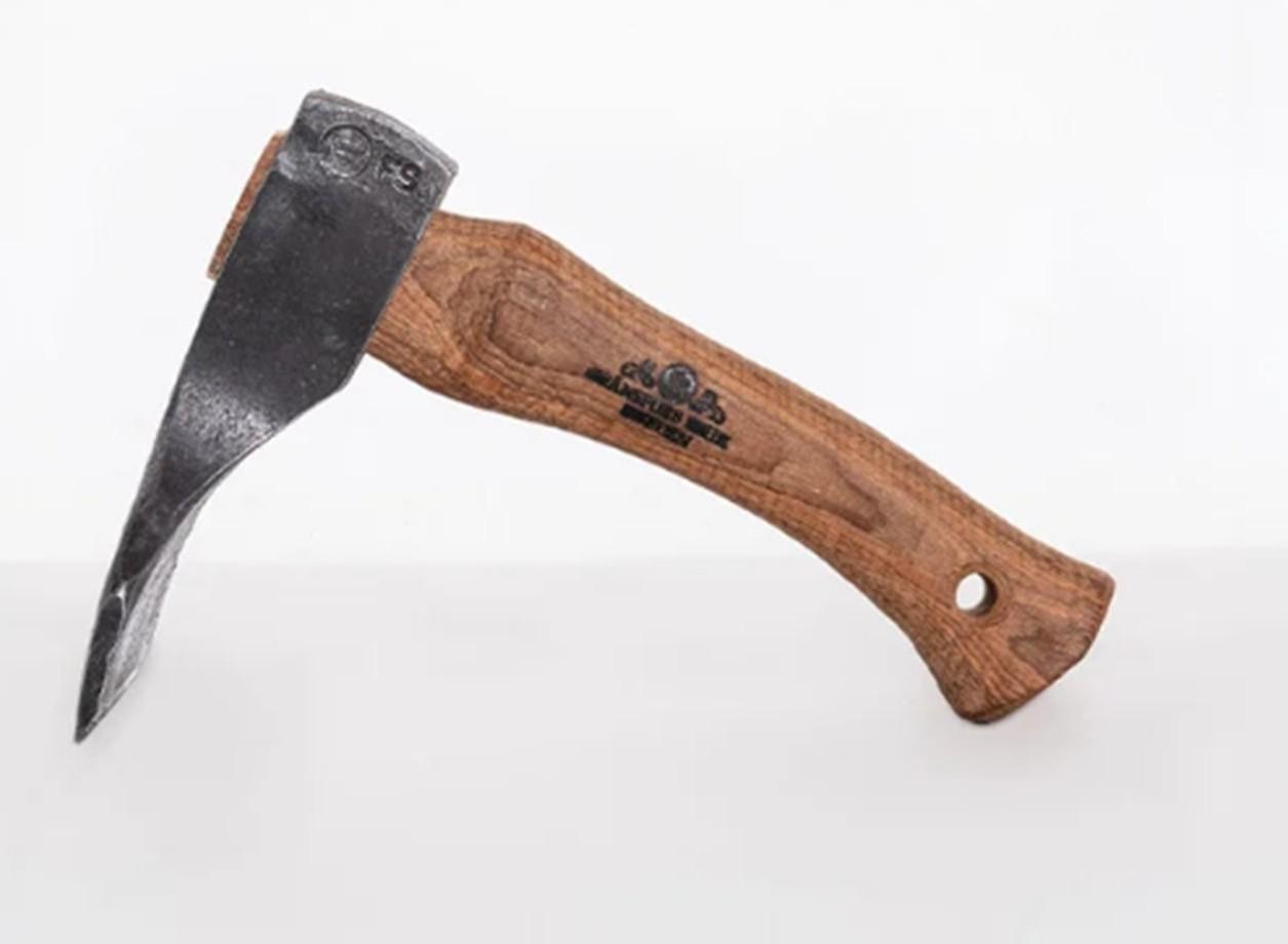 A Gransfors Bruks Small Straight Adze 80 mm, featuring a curved wooden handle imprinted with the Gransfors Bruks logo and a hole at the bottom end, is displayed on its side against a plain white background. Designed for tasks such as log building and shaping wood, this adze serves as an ideal choice for those in need of precise woodworking tools.