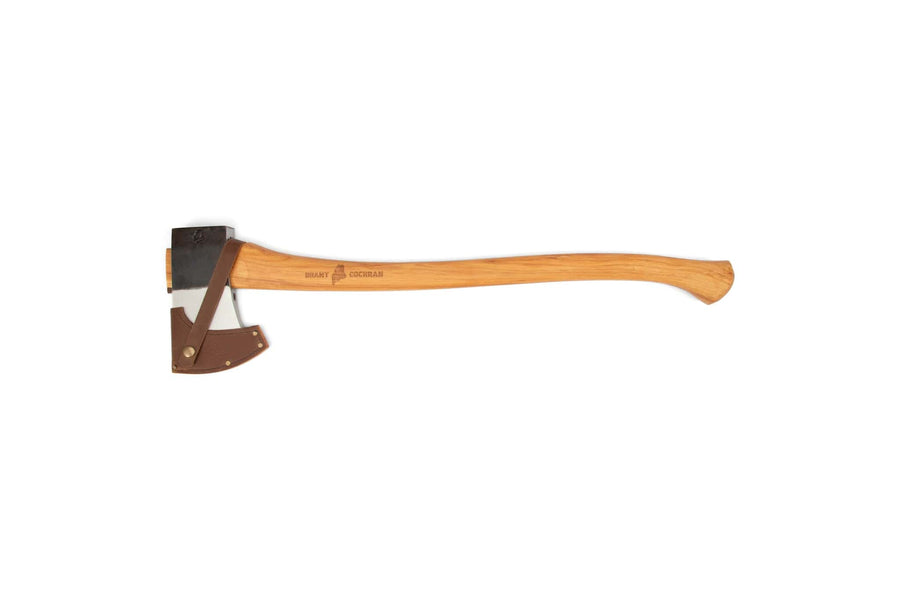 The BNC Brant & Cochran Allagash Cruiser is a hand-forged Maine wedge pattern camp axe with a wooden handle and dark metal blade, partially sheathed in custom leather and displayed on a white background.