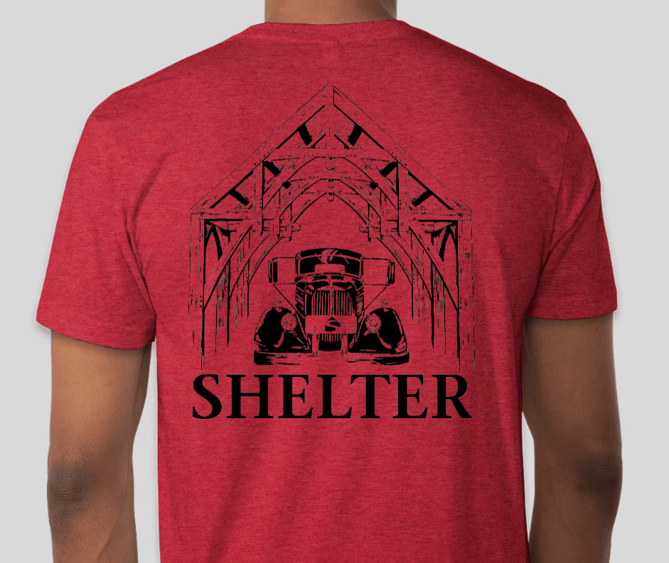 The Shelter Mack Truck T-Shirt by Custom Ink is a red tee with a black line drawing of a Hammer Beam Truss Frame shelter over a vintage 1951 Model A Mack Truck, and SHELTER printed boldly underneath.