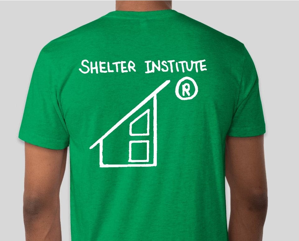 Wearing a Custom Ink 50th Anniversary Adult T-Shirt, featuring "Shelter Institute" and a house logo on the back, someone celebrates half a century of building knowledge.