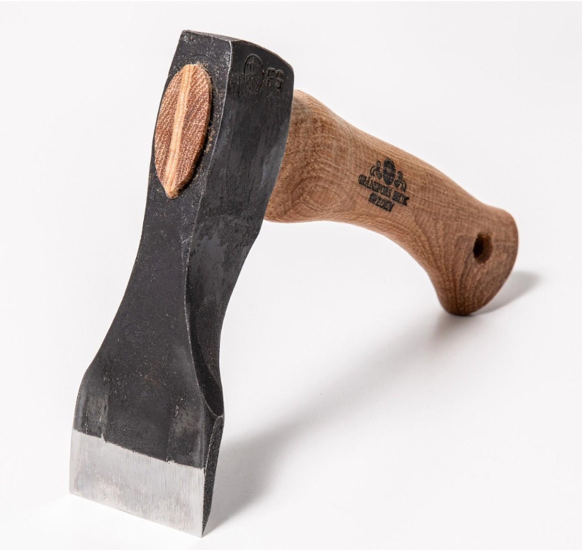 A close-up of a Shelter Institute Small Straight Adze 56mm with a straight wooden handle and a black metal head, displayed against a white background—an essential tool for log building and woodworking tasks.
