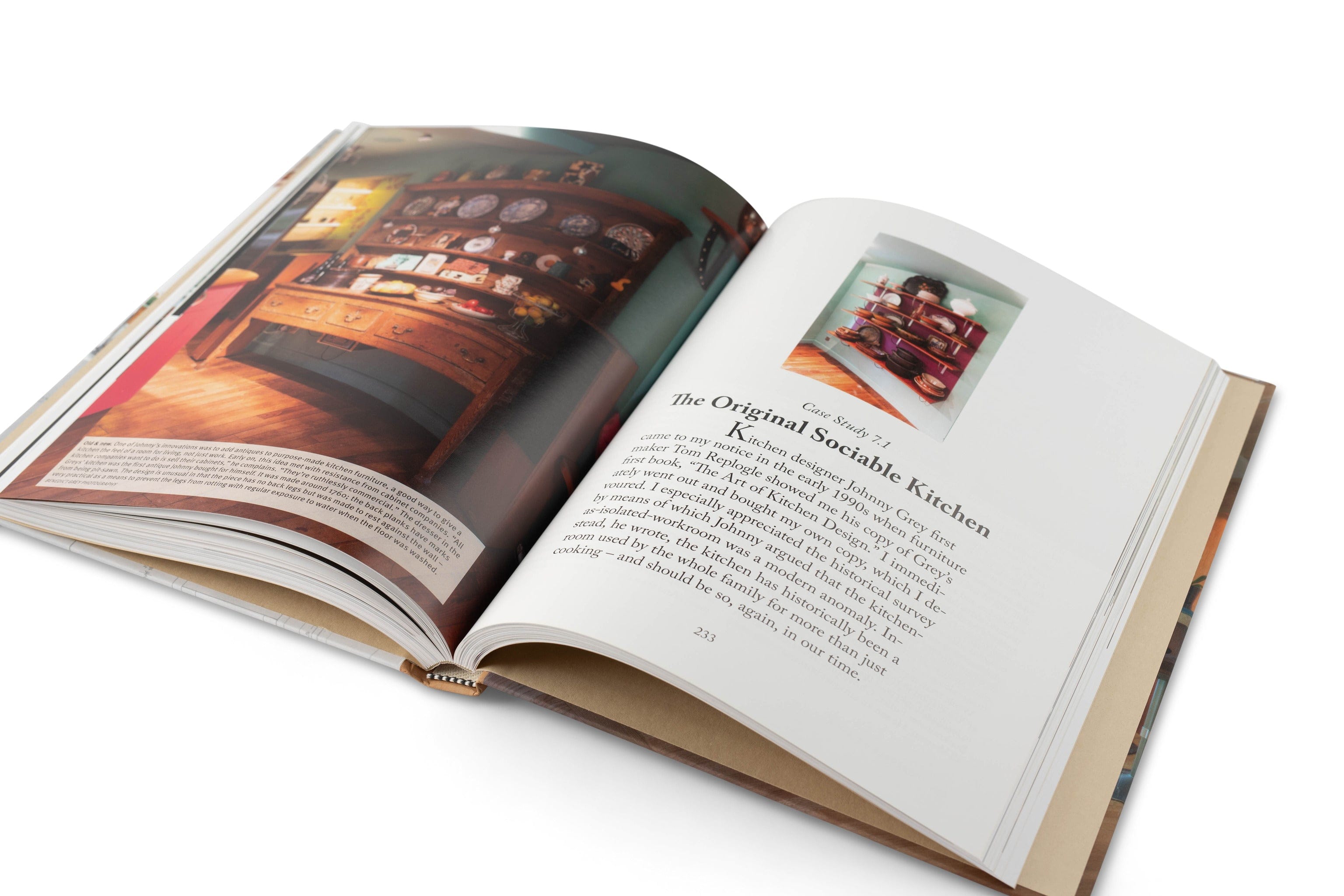 Kitchen Think: A Guide to Design and Construction by LAP lies open on a white surface, showing a chapter with photos of traditional kitchen design and wooden furniture.