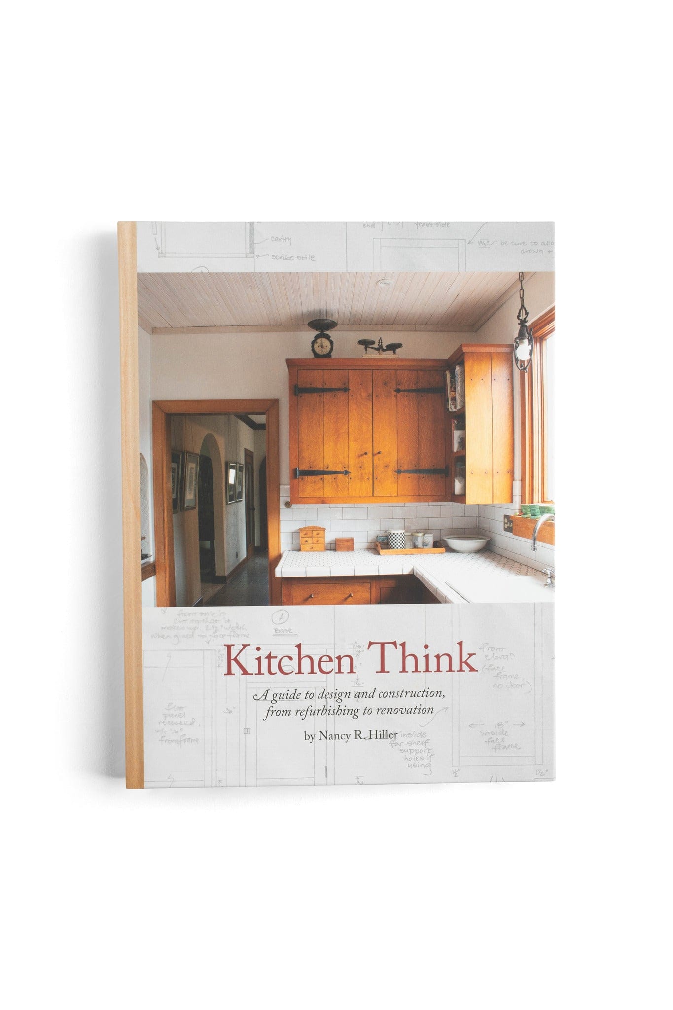 The cover of Kitchen Think: A Guide to Design and Construction by LAP shows a cozy, vintage kitchen with wooden cabinets, a white farmhouse sink, and sunlight streaming through a large window.