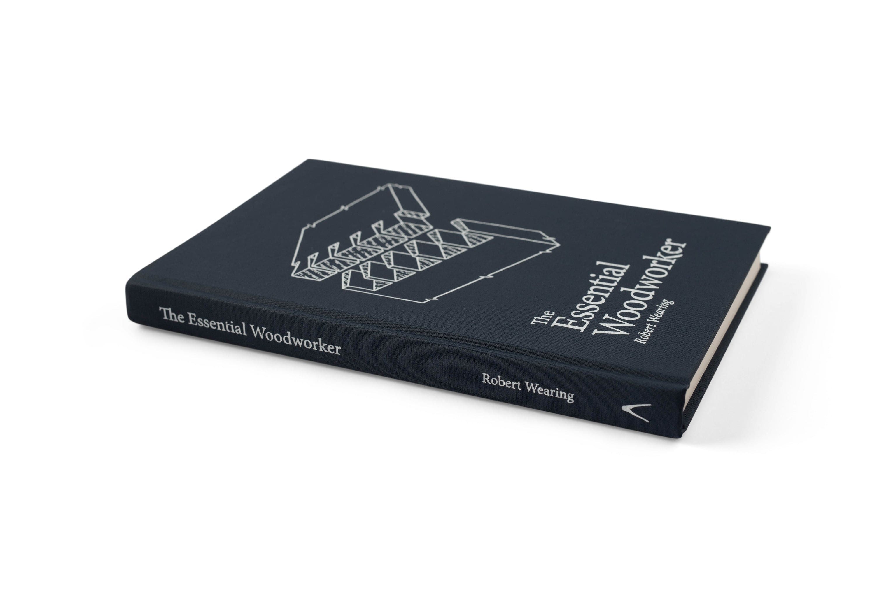 A hardcover copy of LAPs The Essential Woodworker rests on a white background, its cover displaying line illustrations of woodworking joints—ideal for enthusiasts of hand-tool woodworking and traditional methods.