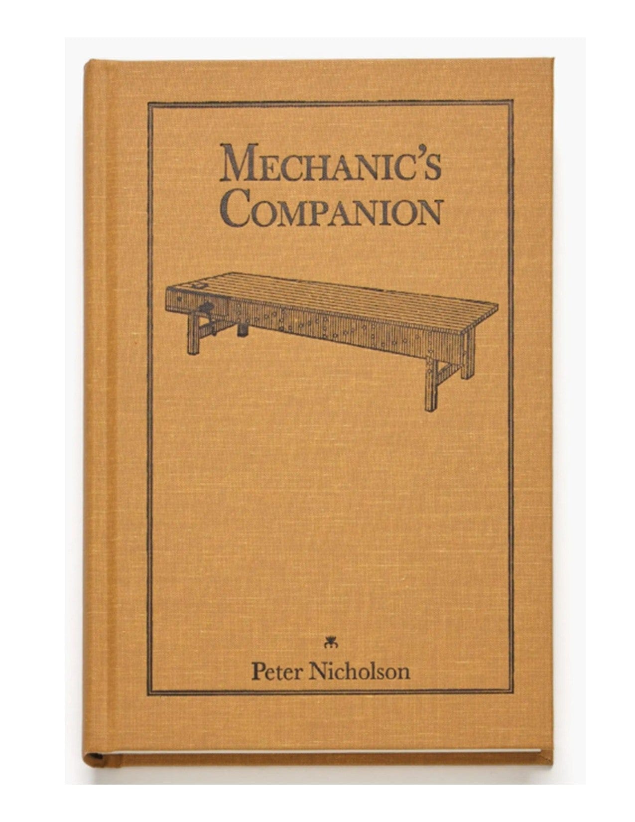 The lap Mechanic's Companion is a tan hardcover woodworking book featuring a black line drawing of a workbench on the cover, and focuses on traditional carpentry and joinery techniques.