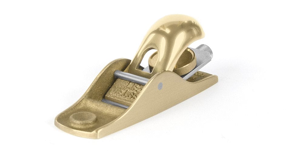 The Lie-Nielsen Low Angle Block Plane No 102, a gold-colored precision tool with a curved handle and adjustable knob, is designed for smoothing and shaping wood. Photographed against a white background.