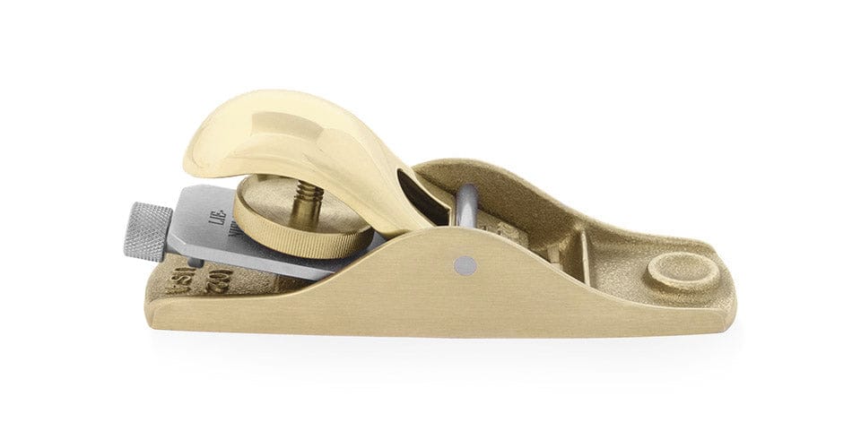 The Lie-Nielsen Low Angle Block Plane No 102, by Lie-Nielsen, is a precision woodworking tool with a brass body and curved handle, shown in profile on a white background.