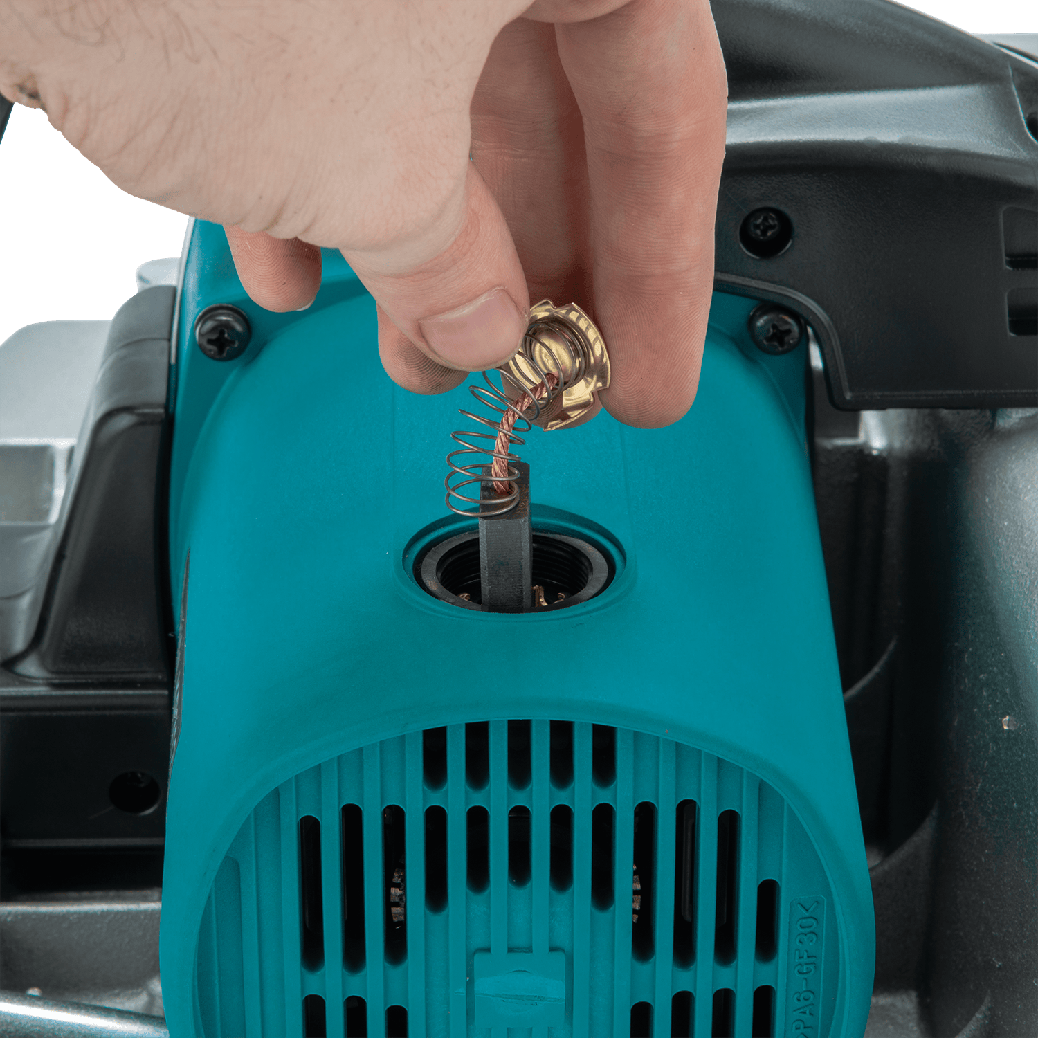 A hand removes a carbon brush with spring from a Makita 12-1/4-in Planer, revealing the internal compartment of this powerful Makita tool.