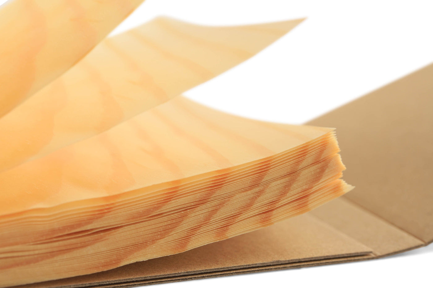 The Kyougi Wooden Notepad by MARU features thin, translucent sheets reminiscent of Japanese craftsmanship, elegantly fanned out and partially stacked on a brown surface against a white background.