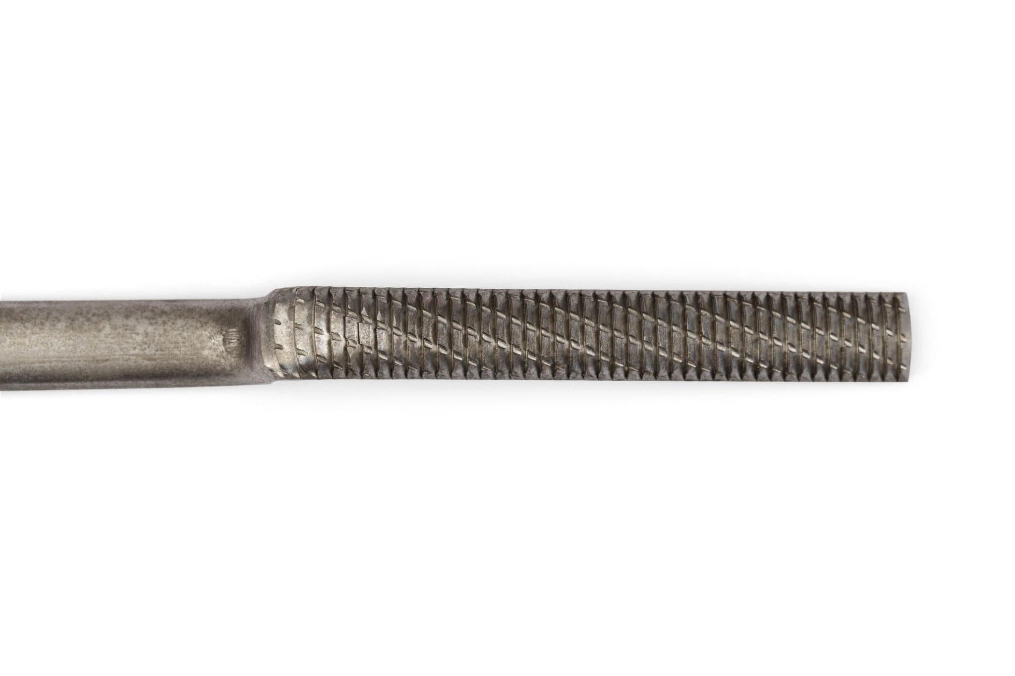 A close-up of the MARU Iwasaki Carving File Crank Neck With Rubber Grip shows diagonal ridges on its cylindrical surface, designed for smoothing or shaping wood. The rubber grip handle appears partially on the left against a white background.