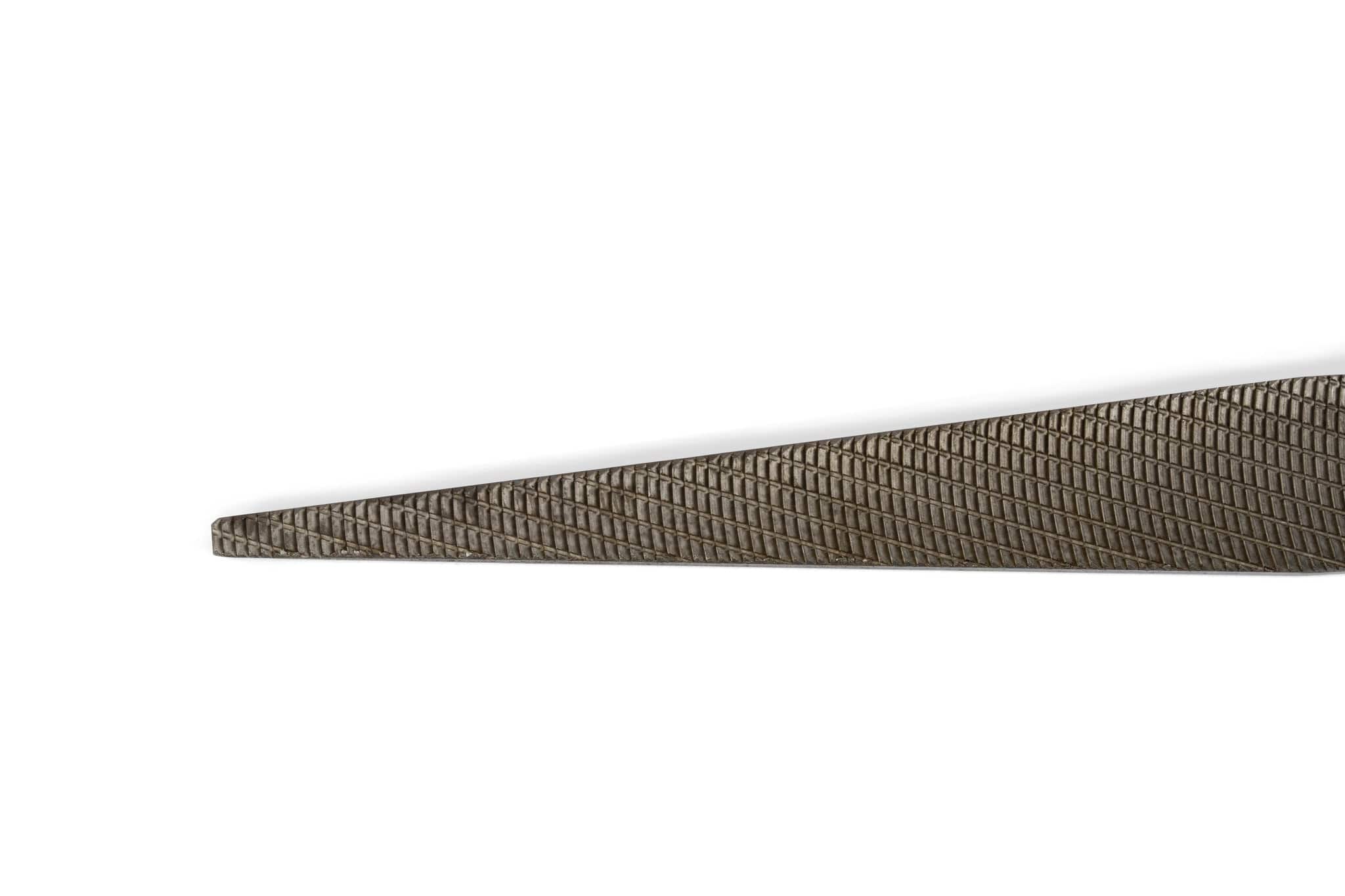 A close-up of the MARU Iwasaki Flat Tapered File Extra Fine shows its diagonally crisscross-textured surface and tapered tip against a white background, with only part of the precision file visible.