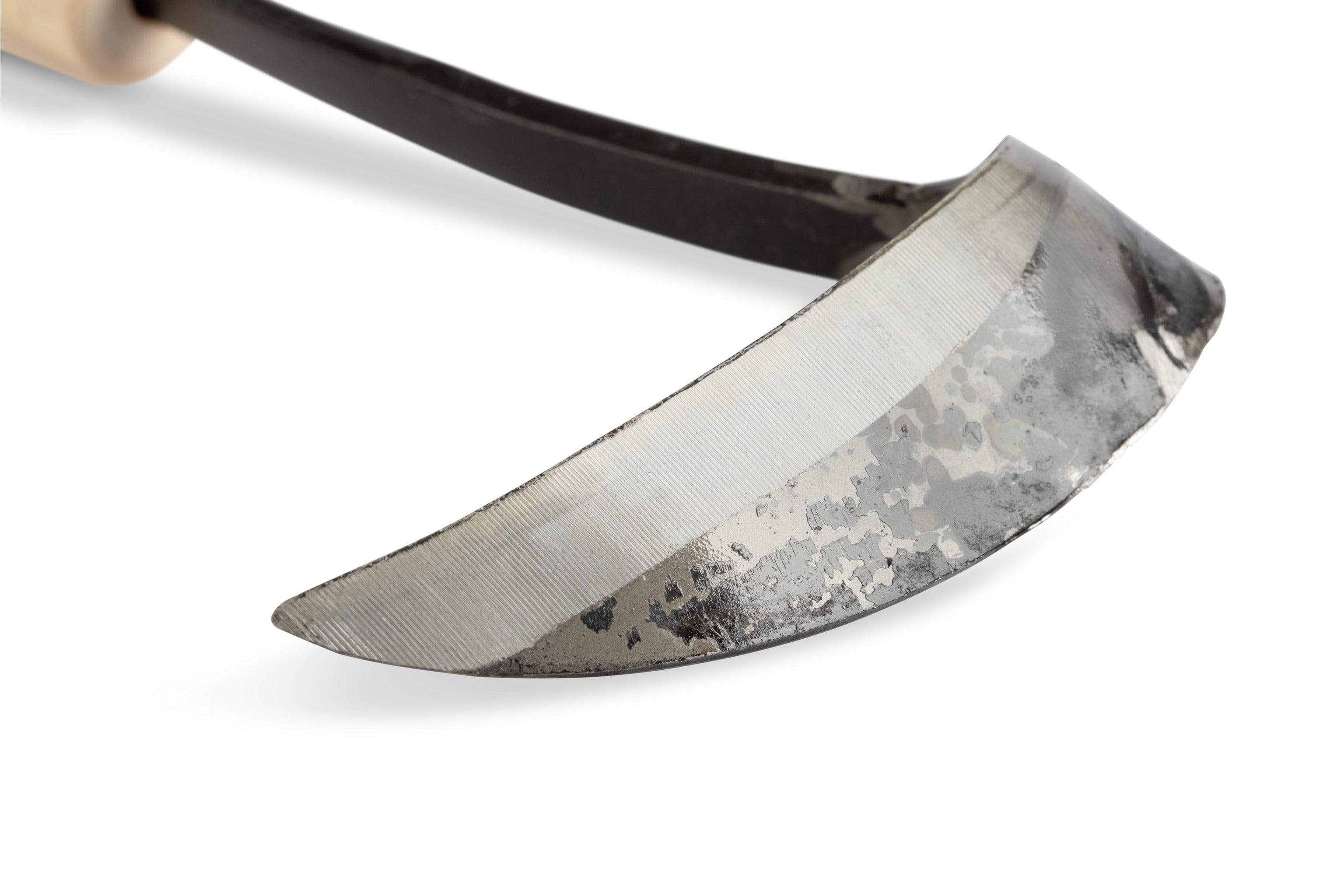 The MARU Japanese Scythe Weeder features a slightly curved high-carbon steel blade with a visible welded pattern, seamlessly attached to the handle, captured in a close-up against a white background.