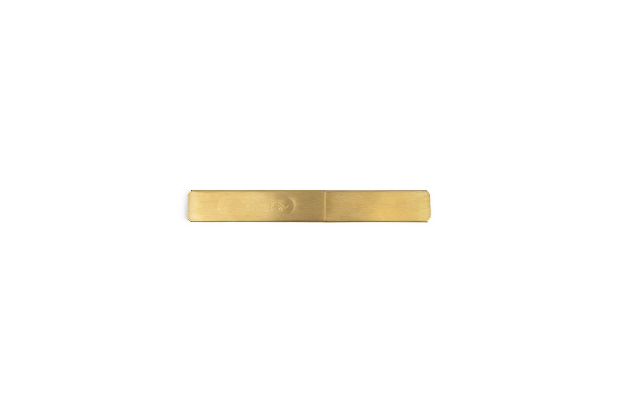 A minimalist, rectangular brass tie clip with a smooth matte finish displayed on white—its clean lines echo the precision of the MARU Japanese Kasaya Marking Knife.