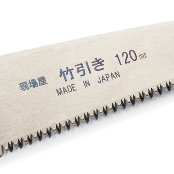 Close-up of a high carbon steel folding saw blade with sharp teeth, showing Japanese text and "Made in Japan 120 mm." Crafted by Maru under the 6 Siblings Saws by INK line, it offers enhanced durability with replaceable blades.