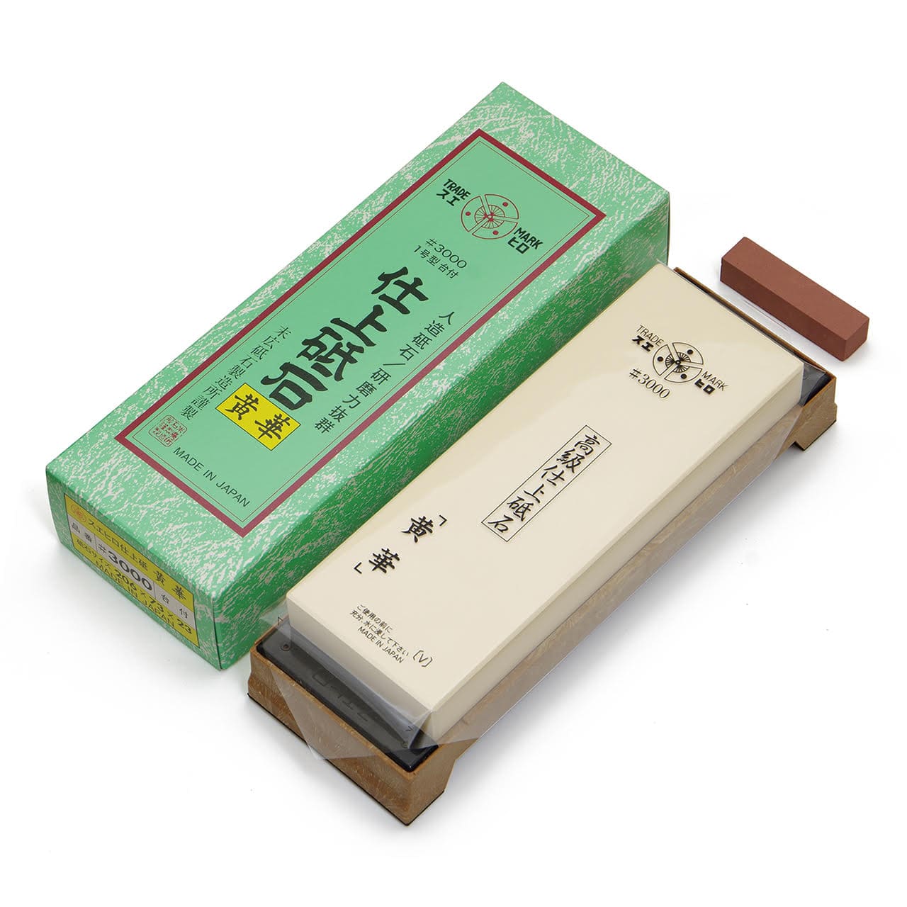 The MARU JAPANESE SHARPENING STONE 3000 GRIT, a rectangular whetstone with Japanese writing, comes in a green box with Japanese text and includes a small brown nagura stone. All items are shown on a white background.