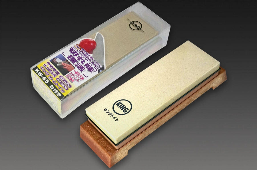 A MARU 1000/6000 King Combination Water Stone with its packaging, featuring a diagram and Japanese text that highlights this high-quality Japanese whetstone, resting on a wooden base.