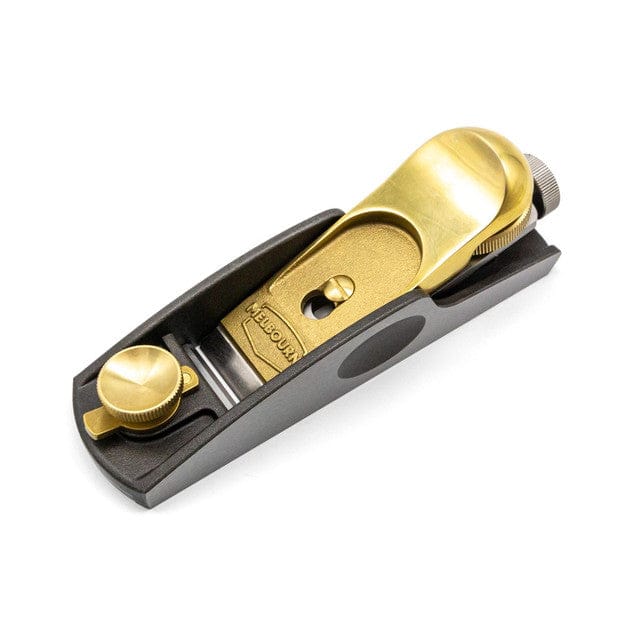 The Melbourne Tool Company Low Angle Block Plane by Melbourne Tool Company features a brass body and M2 High Speed Steel blade, with adjustment knobs—ideal for smoothing wood. Shown on a white background.