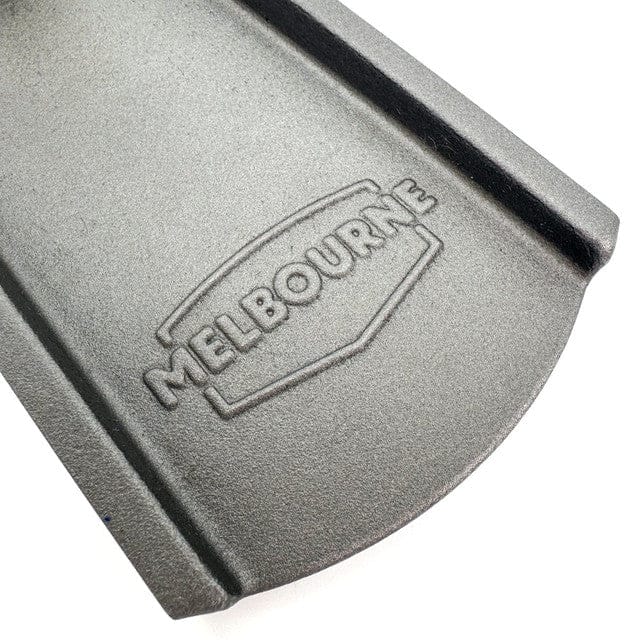Close-up of a gray metal surface with "Melbourne" embossed inside a shield-like design, reminiscent of the craftsmanship in Melbourne Tool Company's Low Angle Jointing Plane.