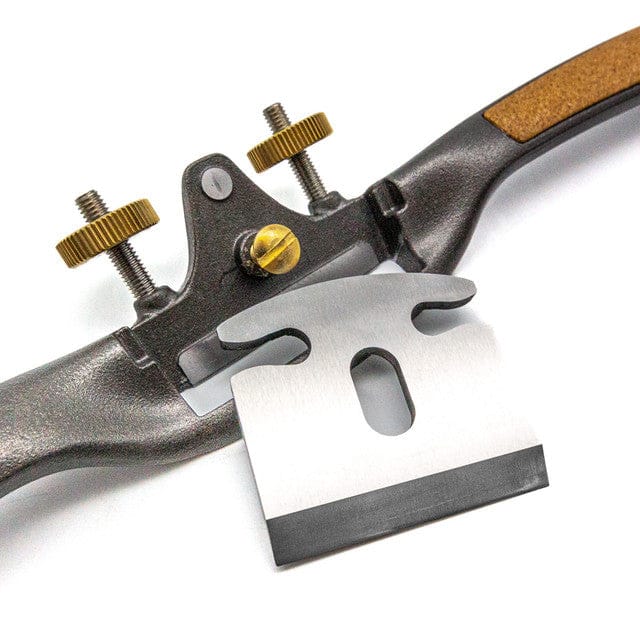 A close-up of the Melbourne Tool Company Sole Spokeshave, featuring convex shaping and brass adjustment knobs with a detached steel blade, designed for shaping and smoothing wood.