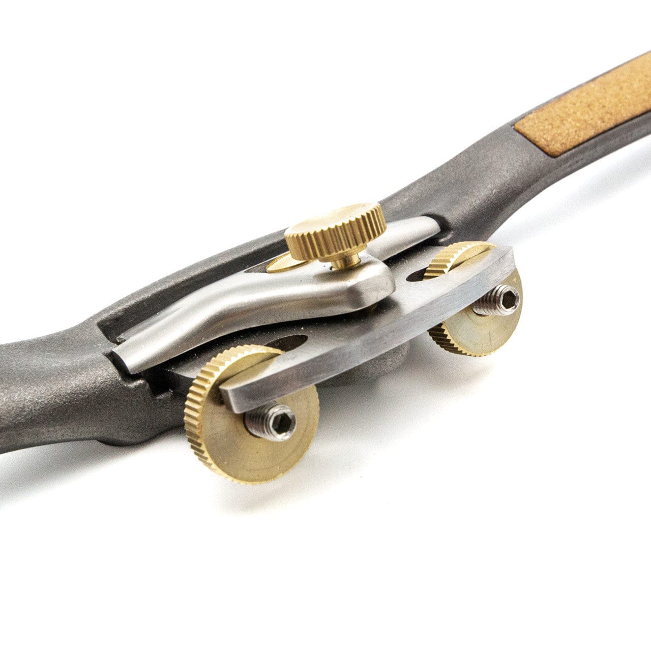 A close-up of the Melbourne Tool Company Sole Spokeshave, a precision woodworking tool with brass adjustment knobs, a partially visible handle, and a cork grip.