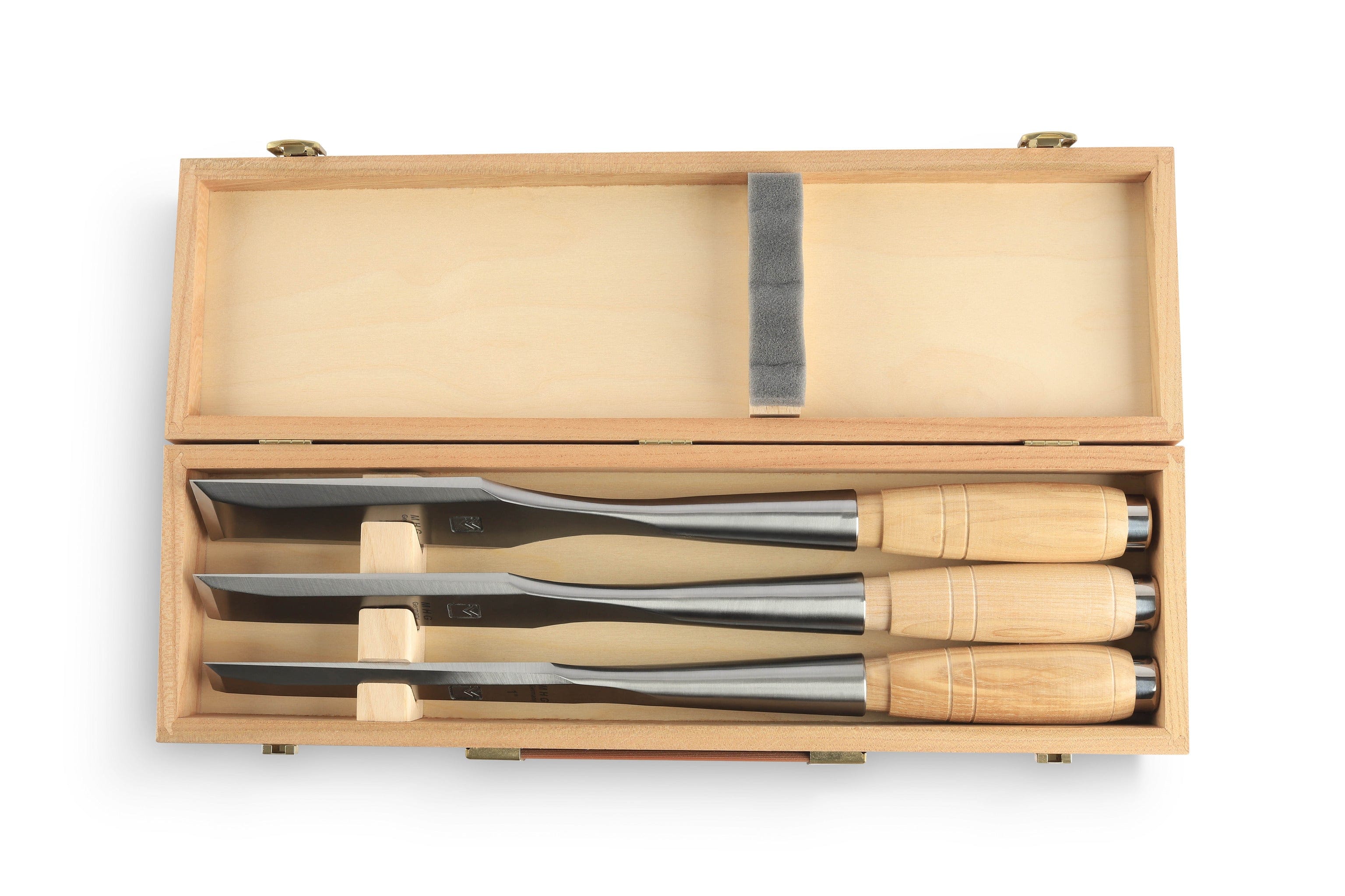 A wooden box holds three MHG Messerschmidt Timber Framing Chisels, featuring beveled metal blades and sturdy wooden handles, secured with wooden brackets.