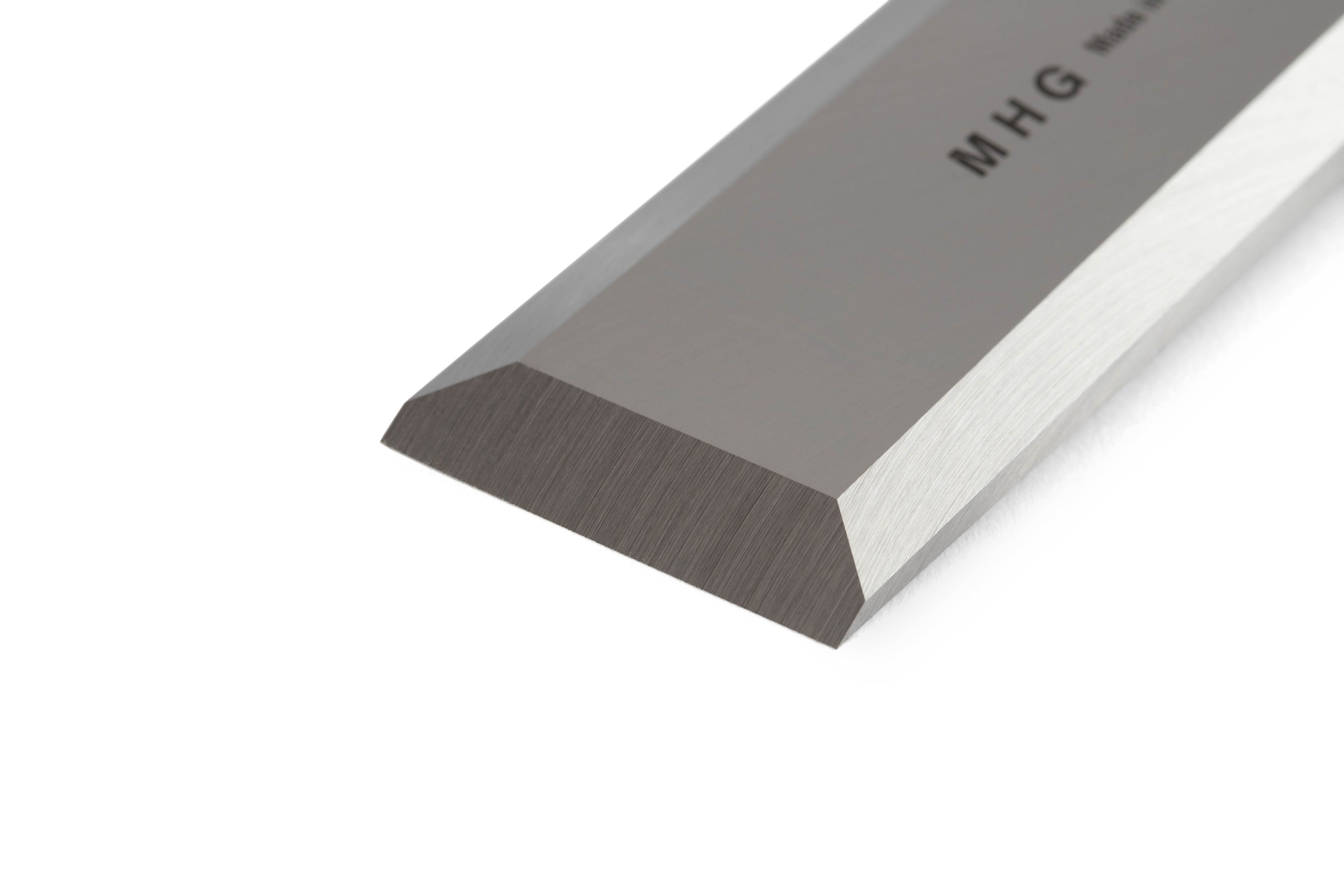 Close-up of the MHG Carpenter Chisels beveled metal blade, featuring sharp edges and a reflective finish. Marked with MHG, this German-engineered tool is highly valued by woodworkers for its quality and precision.