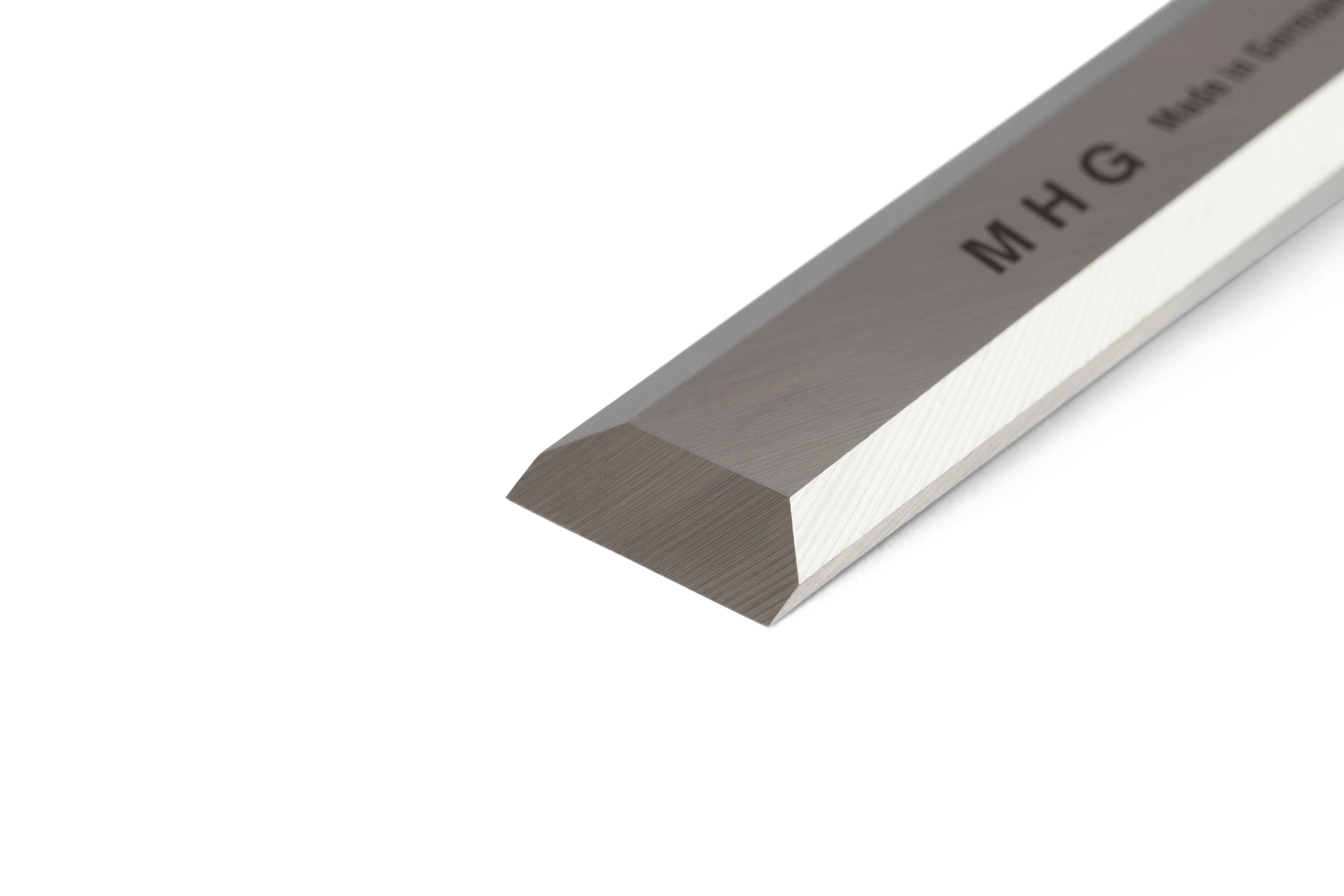 A close-up of the MHG Firmer Bench Chisel blade with a beveled edge, engraved with MHG and Made in Germany—an essential tool for fine woodworking from the MHG brand.