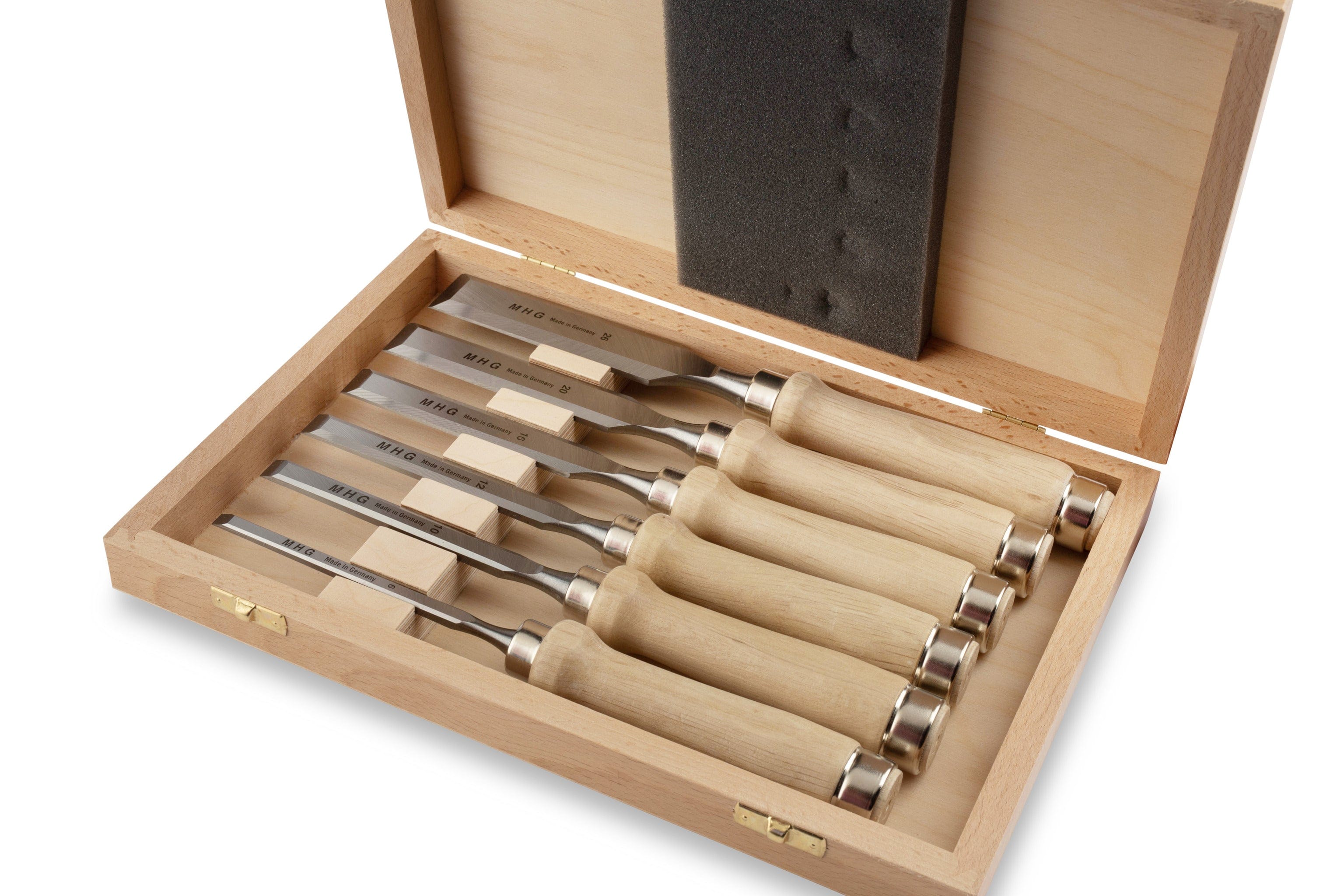 An MHG wooden box containing six MHG Firmer Bench Chisels with light-colored handles and steel blades, neatly arranged in a row.