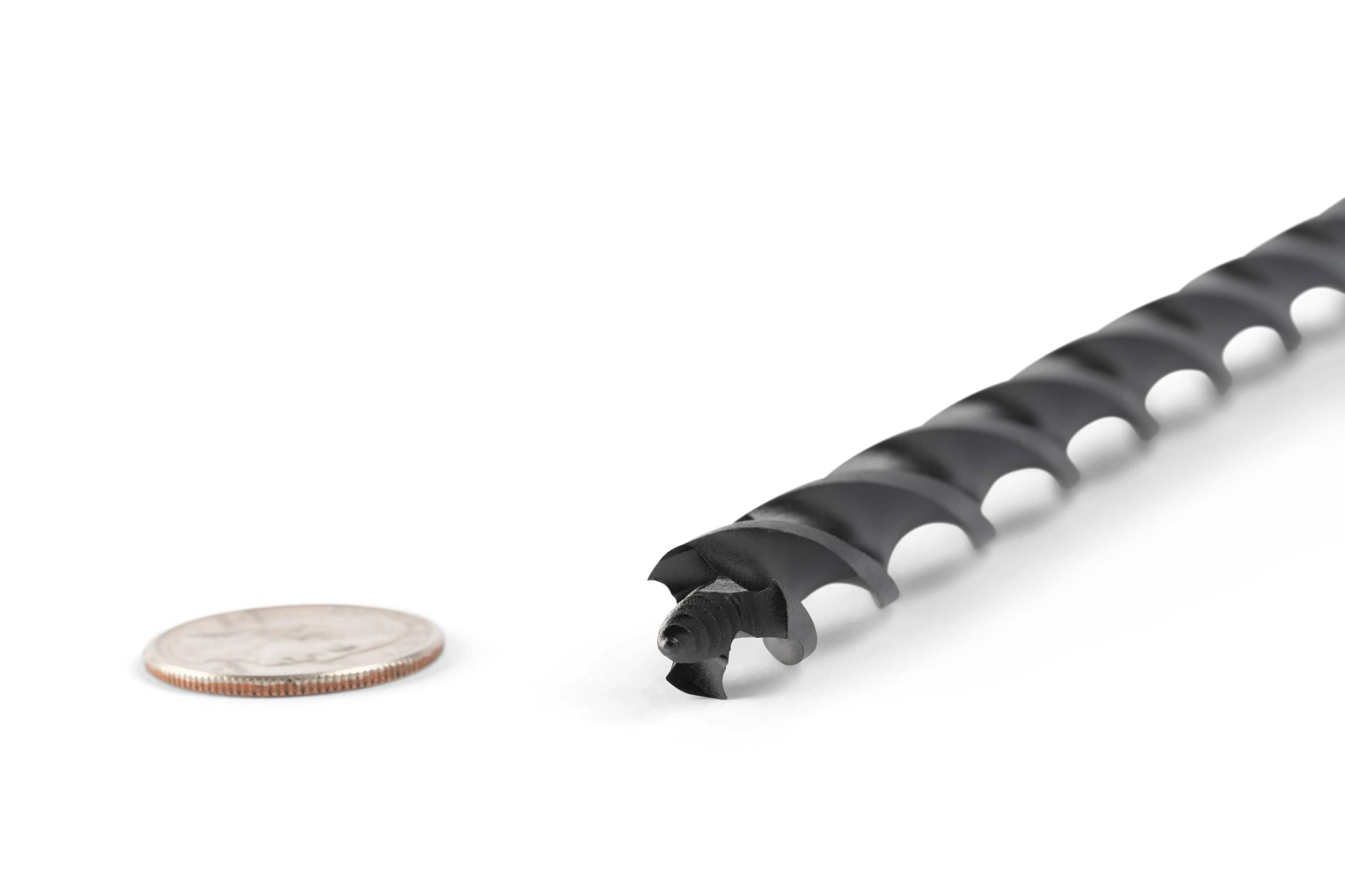 A close-up of a black OWL Wood Owl Ultra Smooth Tri-Cut Auger Bit 18-in beside a U.S. quarter on a white background, showcasing its size, efficient chip ejection, and advanced design.