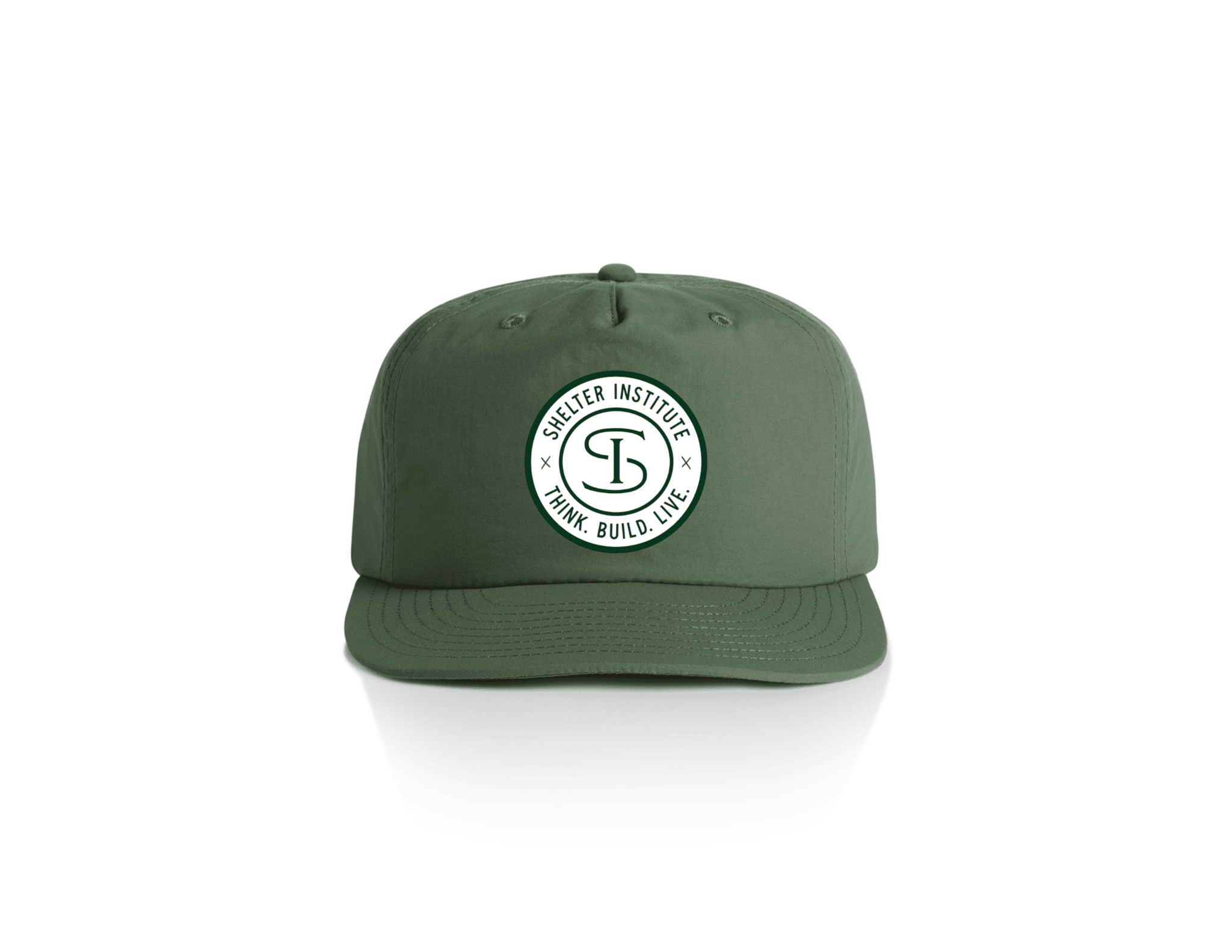 The Shelter Institute Nylon Cap by Riptide Print Company features a green nylon design with a round white patch displaying "Shelter Institute" and "Think. Build. Live." around an SI logo—perfect for timber frame enthusiasts. Shown on a white background.