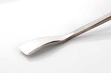 Close-up of a metal butter knife with a curved blade on a white surface, reminiscent of the precision seen in carving chisels like the ROB Two Cherries Gouge Sweep #6.