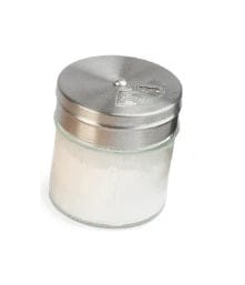 A Shelter Sharpening Kit by Shelter Institute, essential for sharpening tools, sits alongside a glass sugar dispenser with a metal lid—both commonly found among woodworking essentials.