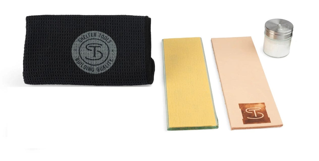 The Shelter Institute Shelter Sharpening Kit includes a black textured cloth with a circular logo, a yellow rectangular sharpening stone, a leather strop with logo patch, and a small metal container—an essential set for woodworking tools.