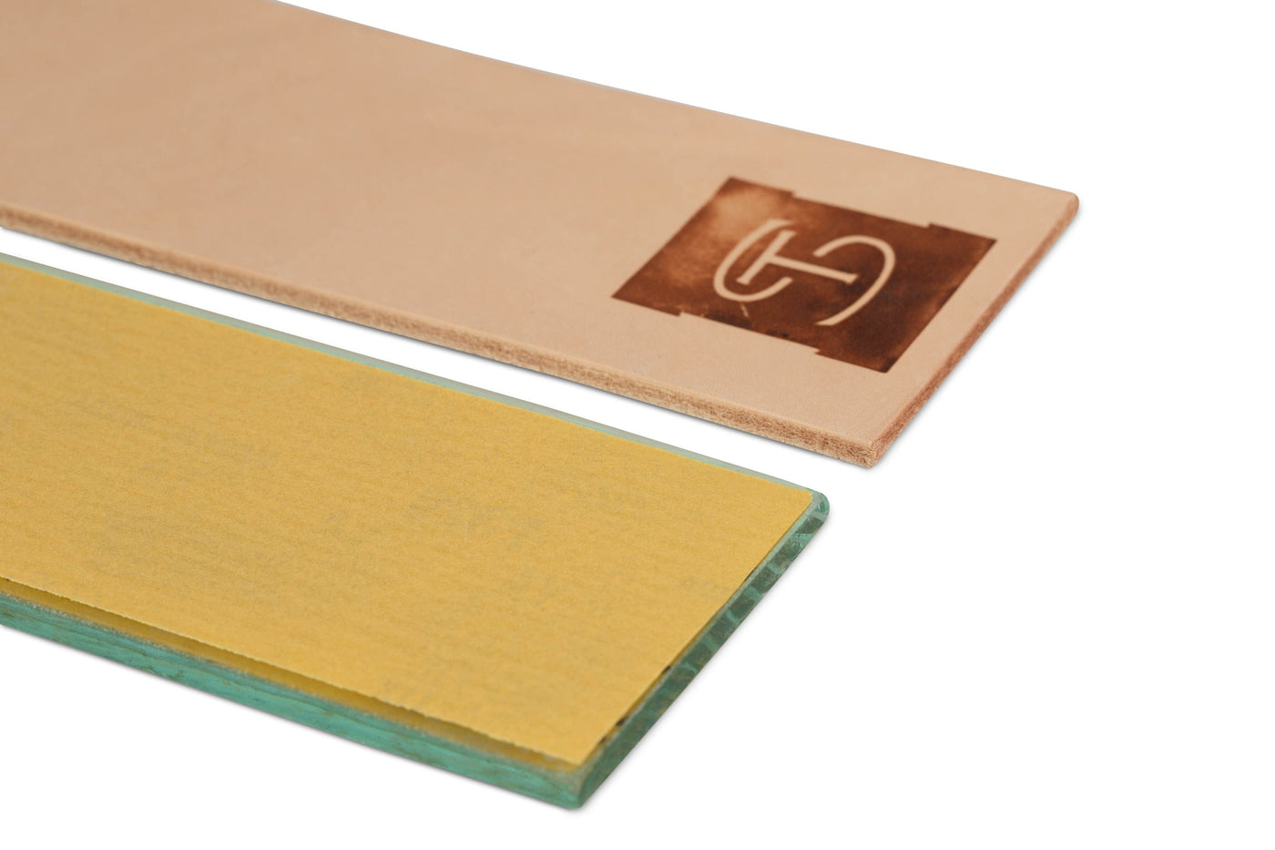 The Shelter Institutes Shelter Sharpening Kit features two rectangular slabs: a beige top with a logo in the corner and a yellow bottom with green edges. Both have smooth surfaces and sharp edges, perfect for woodworking enthusiasts seeking precision similar to using a Veritas MKII Honing Guide.