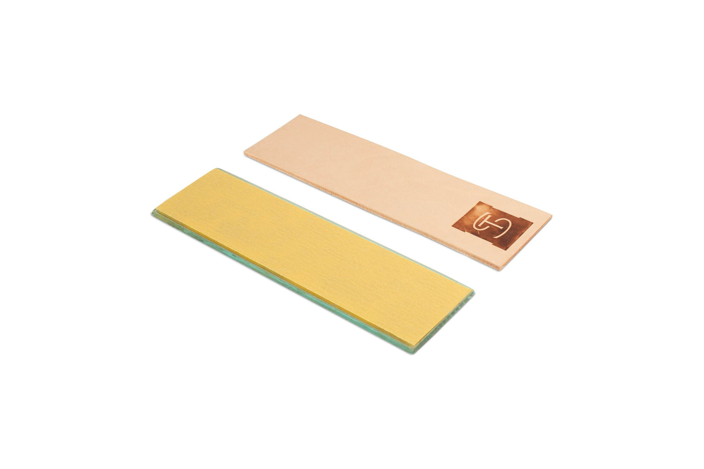 The Shelter Sharpening Kit by Shelter Institute includes two rectangular strops, one with a beige leather logo surface and the other with a green abrasive surface, arranged side by side on a white background. Perfect for your woodworking sharpening kit or use with the Veritas MKII Honing Guide.