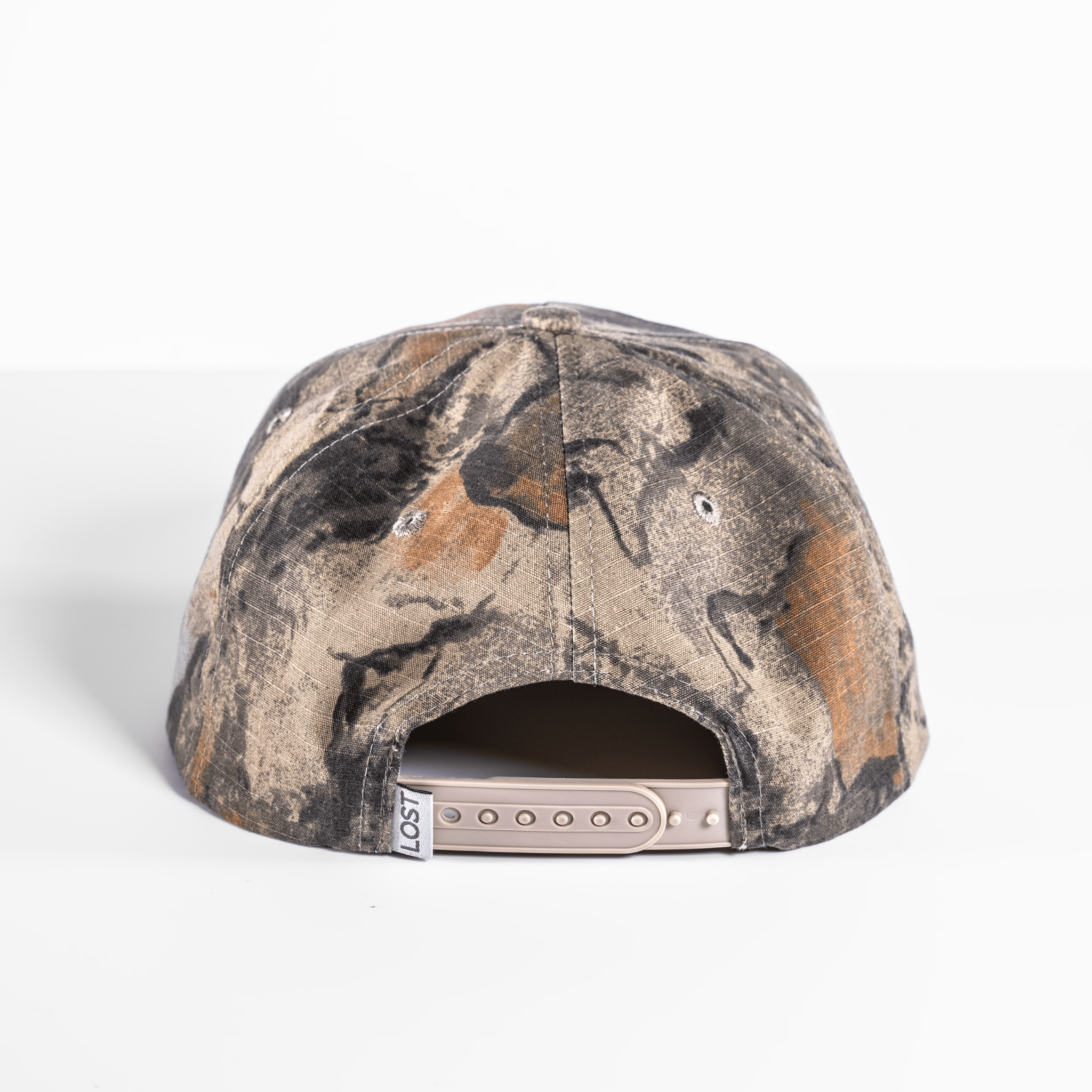 The Shelter Institute Camo Hat is displayed from the back on a pristine white surface, highlighting its camouflage design.