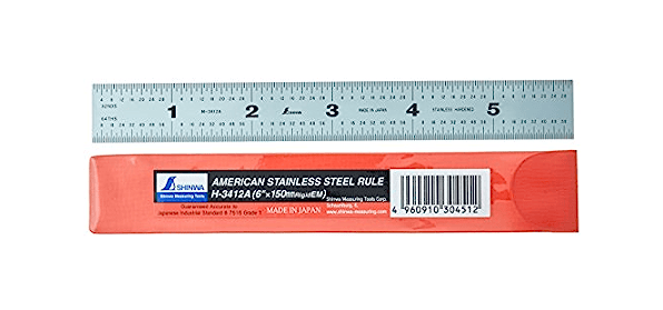 The SHWA STAINLESS STEEL RULE 6 INCH ENG/MET features black markings and a satin chrome finish, shown above its red and white packaging labeled American Stainless Steel Rule.
