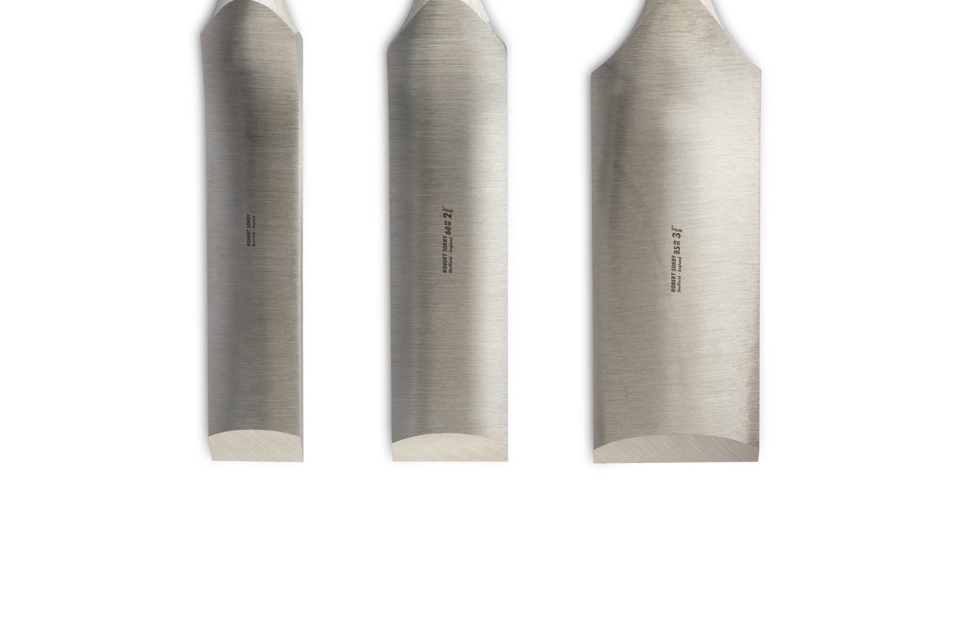 Three Robert Sorby Timber Framing Slicks, expertly crafted with angled tips, are displayed vertically against a white backdrop. Each has engraved text for size and the SOR brand, highlighting the quality of Sheffield Steel.