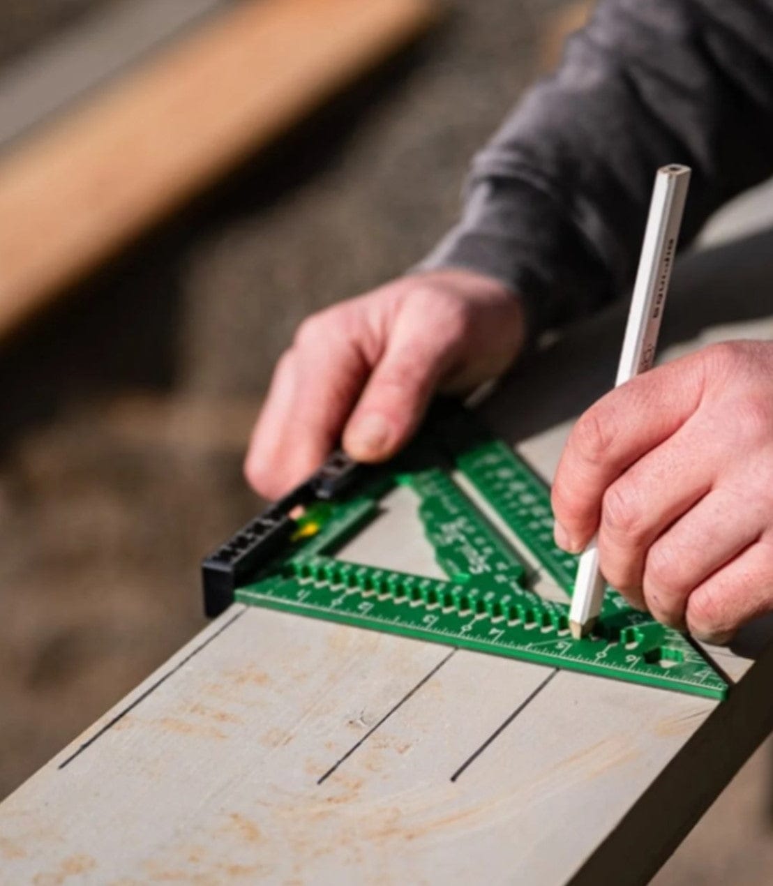 Using the Squi.Jig Fusion 7.5 inch Pro Rafter Square and a pencil, a person marks precise lines on a wooden board.