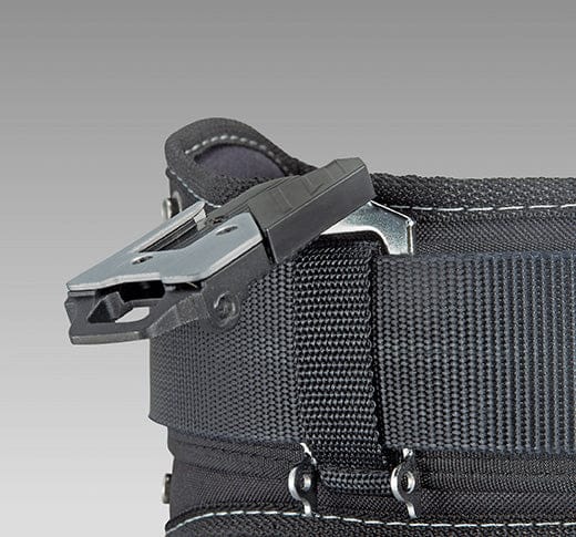 Close-up of the TAJ CLIP-n-HOLD™ BELT CLAMPING SYSTEM featuring a rugged metal clip attached to reinforced black fabric with white stitching, designed for durability and reliability, set against a plain gray background.