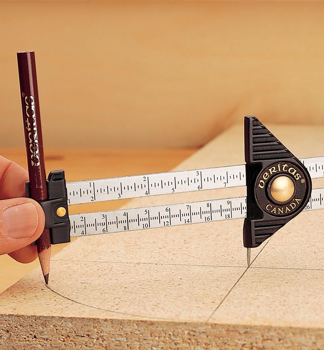 A hand uses a VER Carpenters Guage with a pencil to draw a precise arc on wood. The tool’s scale and adjustable slider from VER ensure accurate measurement and marking.