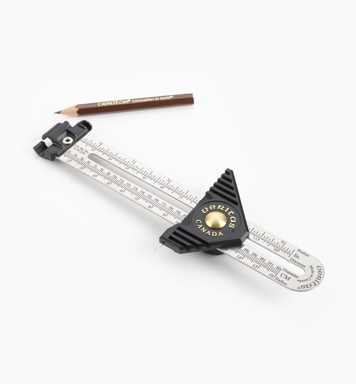 The VER Carpenters Gauge, featuring a metal ruler, black adjustment knobs, and a sharp marking pin, is placed next to a short brown pencil on a white background.
