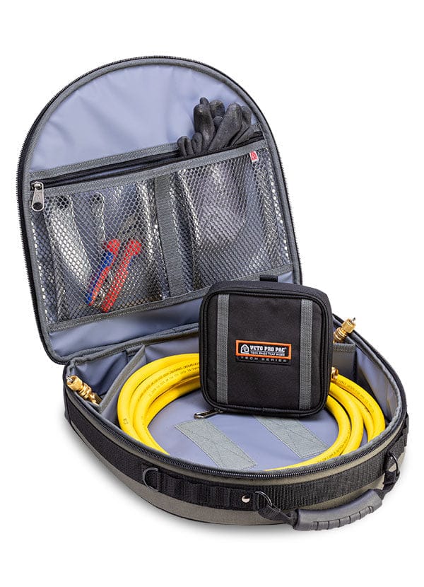 The VET Hose Hauler is an open storage organizer featuring a yellow hose, black pouch, black gloves, and two red-handled tools neatly stored in internal mesh pockets.
