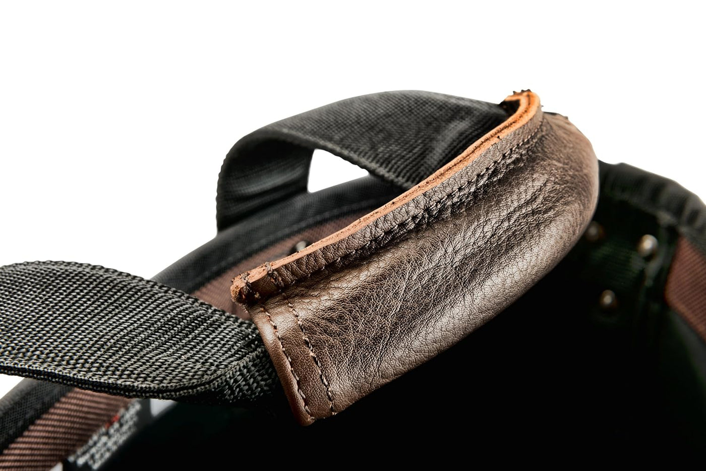 Close-up of a brown leather handle attached to the VET Cargo Tote made from black fabric, showcasing stitching details and texture. The background is white.