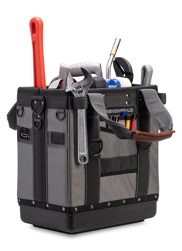 A gray and black tool bag, The Wrencher by VET, comes with a wrench, a red-handled tool, and screwdrivers. It features shoulder straps, side pockets, and customizable storage pockets for organized convenience.