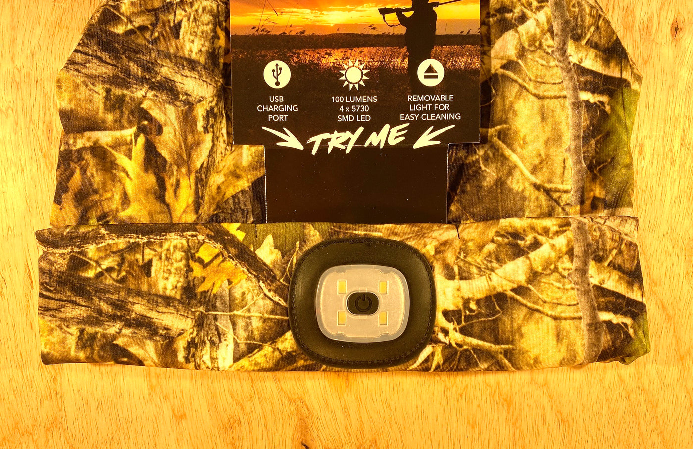 The Shelter Institute Night Scout Camo Hunting Headlamp Beanie features a built-in 100-lumen removable LED, USB charging port, and easy-to-clean design—ideal as an LED beanie for outdoor adventures. Packaging highlights these convenient features.