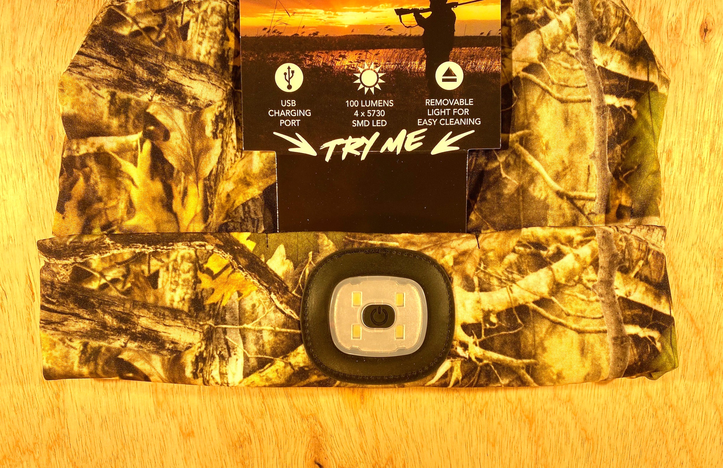 The Shelter Institute Night Scout Camo Hunting Headlamp Beanie features a built-in 100-lumen removable LED, USB charging port, and easy-to-clean design—ideal as an LED beanie for outdoor adventures. Packaging highlights these convenient features.